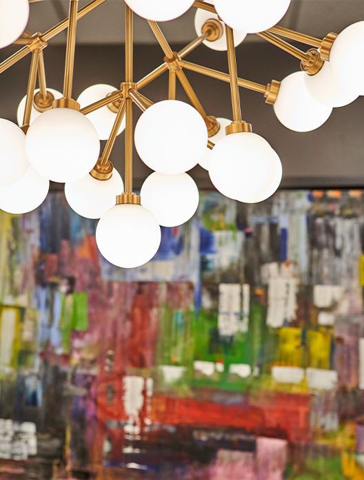 light fixtures in front of a colorful painting